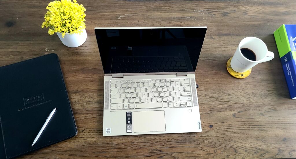 Dr. Oscar Cornelio working desk with an open laptop, a cup, a notebook and a book.