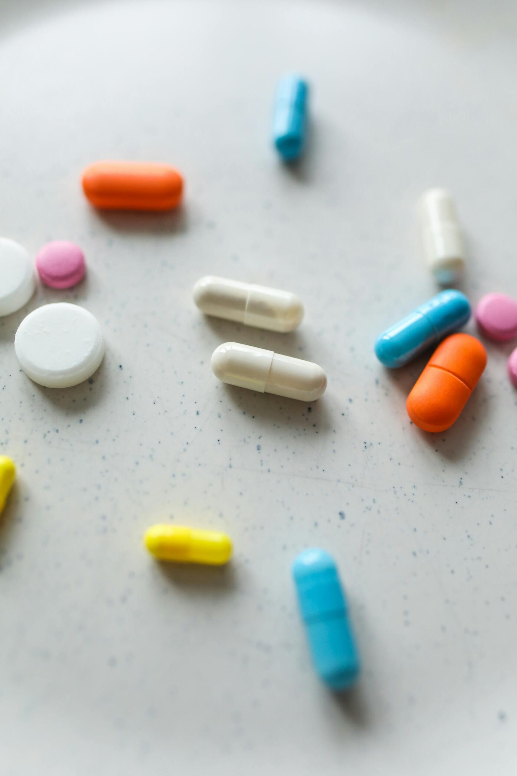 A creative array of colorful pills and tablets spread on a surface, showcasing various pharmaceutical forms.